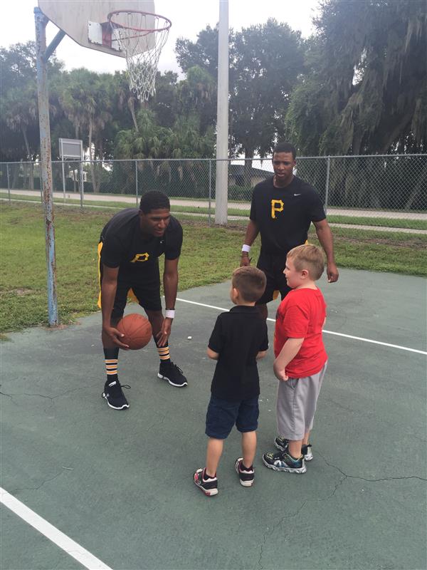 students and Pirates players on basketball court